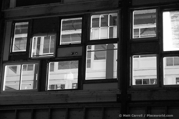 many windows built into side of warehouse, black and white