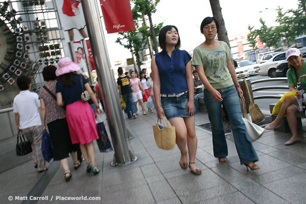 two women walking down shopping street