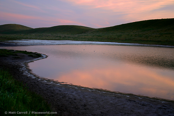 small lake in hilly landscape at dawn