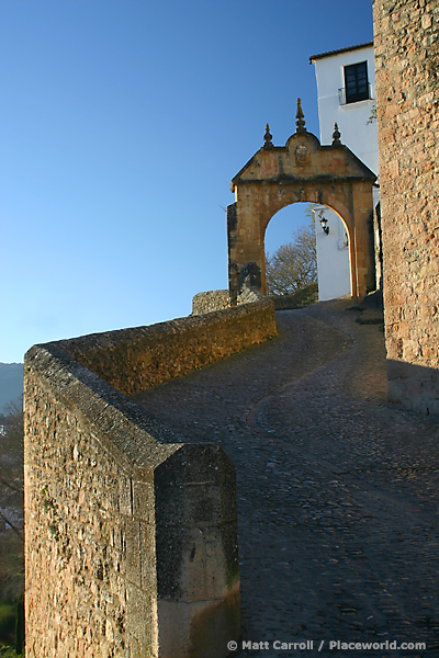 Puerta de la Exijara, Ronda: stone city gate with white house on steep slope