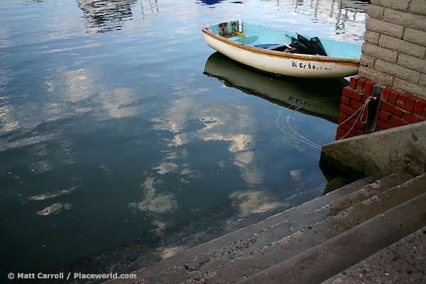 Public beach coastal accessway at high tide and small moored boat - photographer Matt Carroll